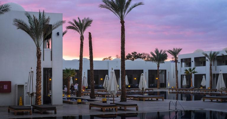 Tres personas hablan en la zona de hamacas de un hotel